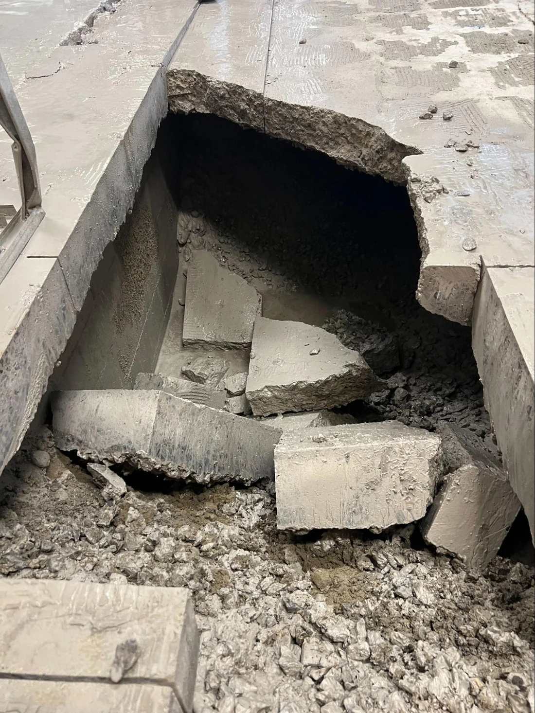 The broken floor where the water main burst through
