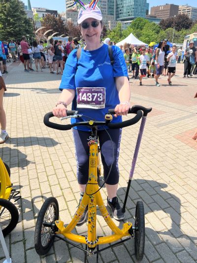 A rider in a LiquidGym shirt with a race bib on an Alinker