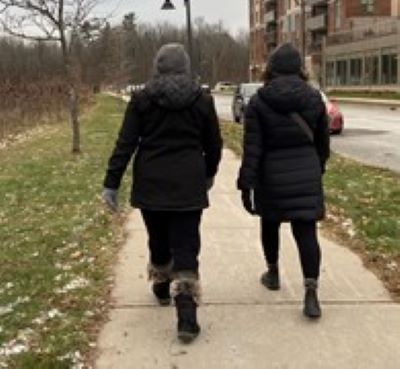 Two people walking together along a path in winter coats