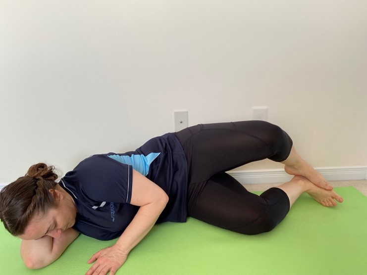 Side-lying glute exercise on a mat