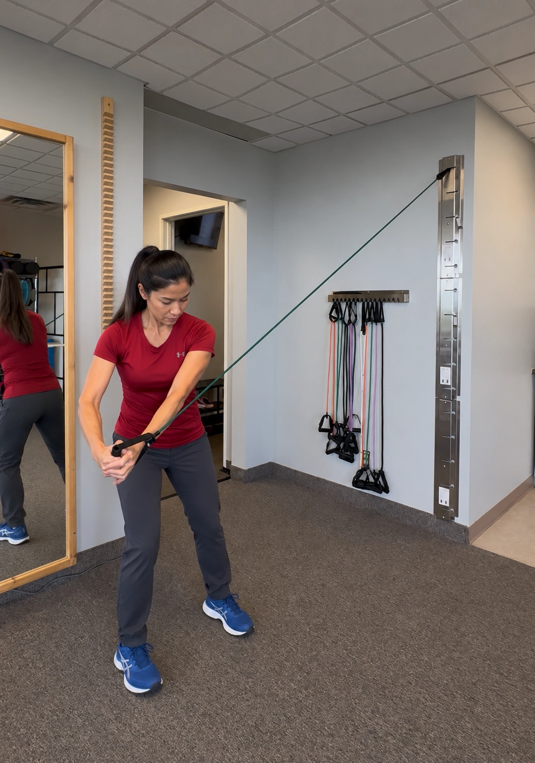 A client performing a resistance band rotation exercise at the LiquidGym clinic