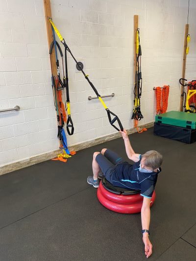 Seated sit-back crunch using the TRX