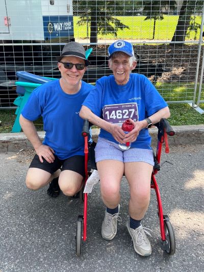 Two participants with a race bib and a walker