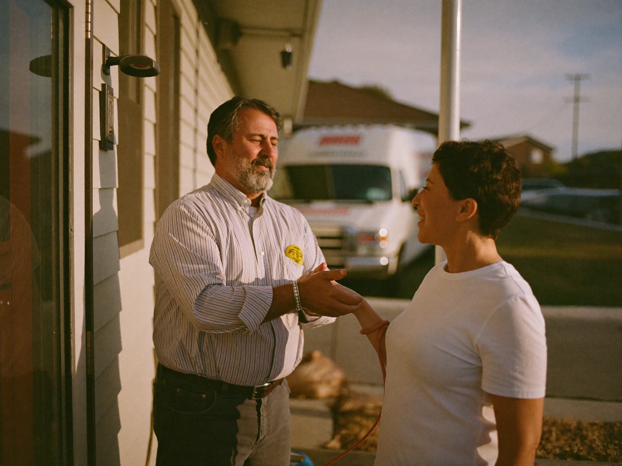 A plumbing business owner talking with a homeowner at her front door