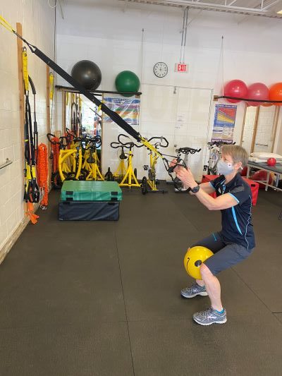 A ball held between the knees during a squat