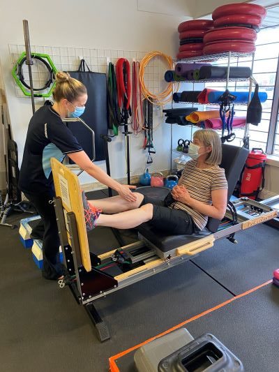 Guided knee exercise on a therapy table at LiquidGym