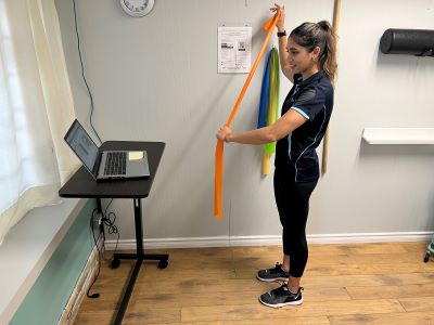 A therapist guiding a patient through exercises over video